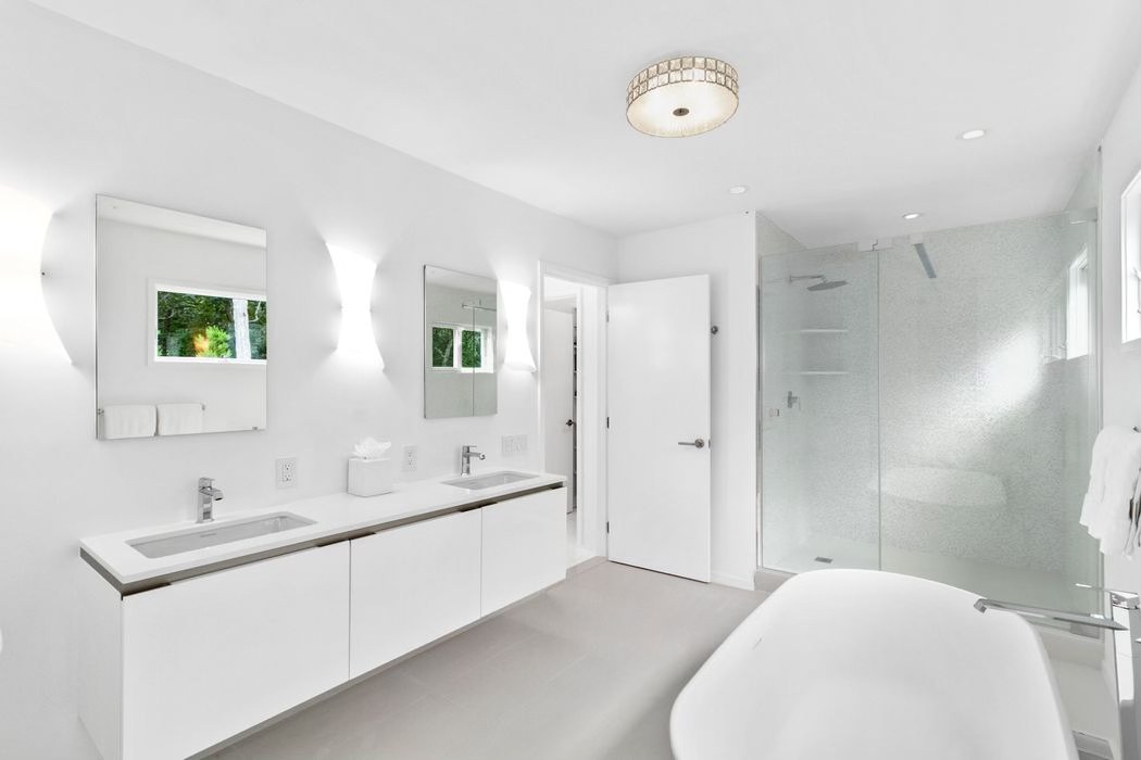 White bathroom with a floating vanity and freestanding tub