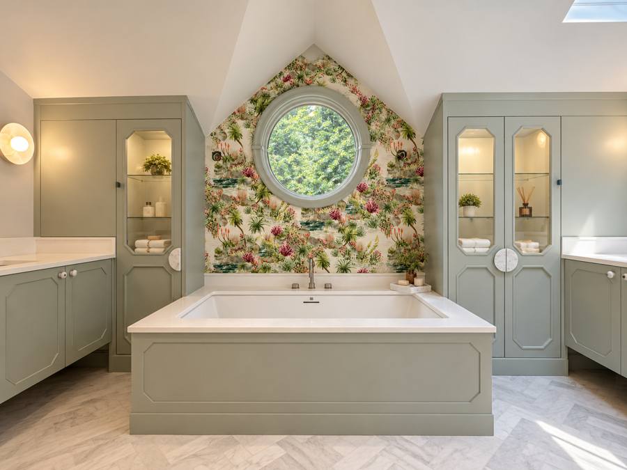 Primary bathroom with sage cabinetry and a built-in soaking tub