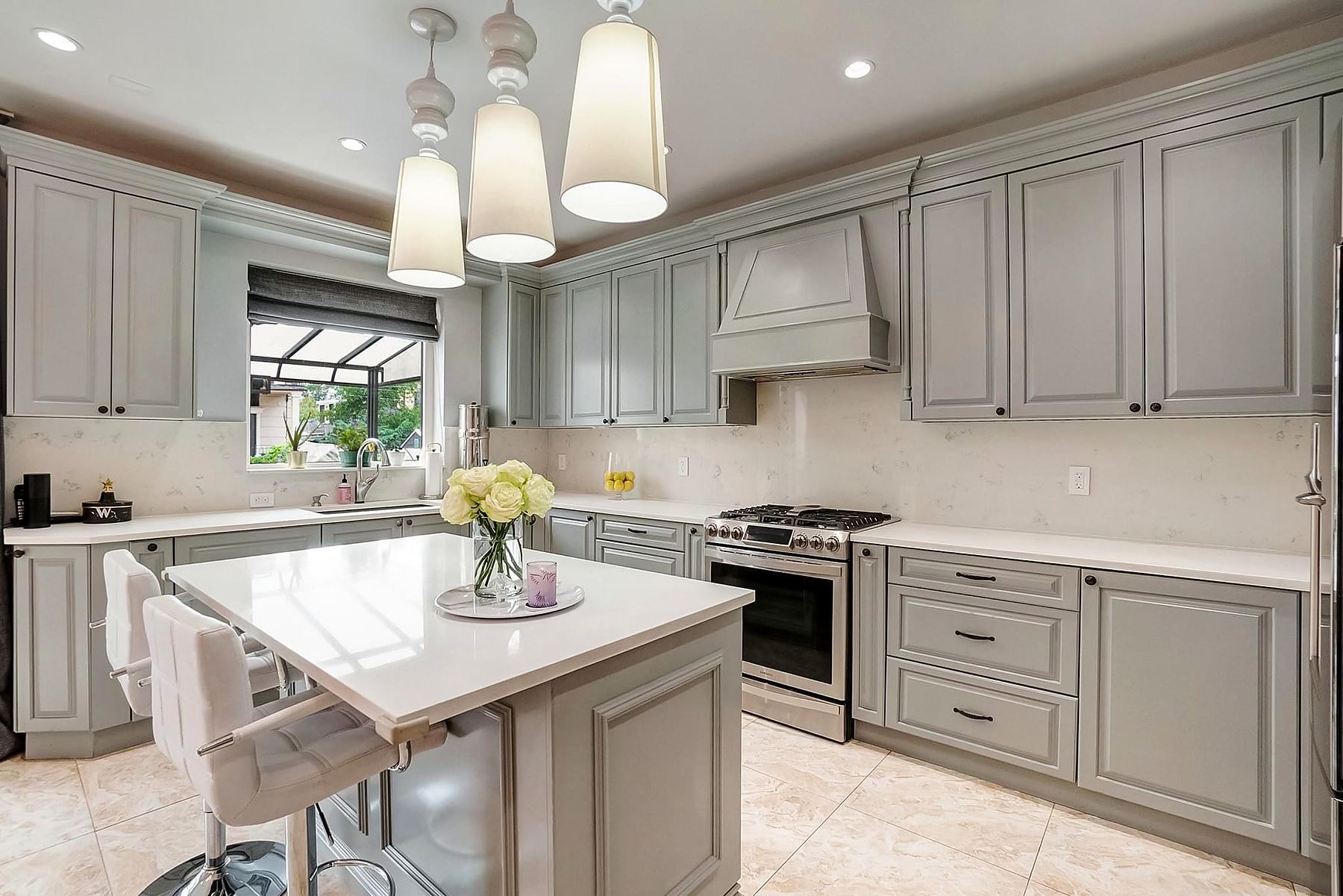 Gray kitchen with raised-panel cabinets, an island, and pendant lights