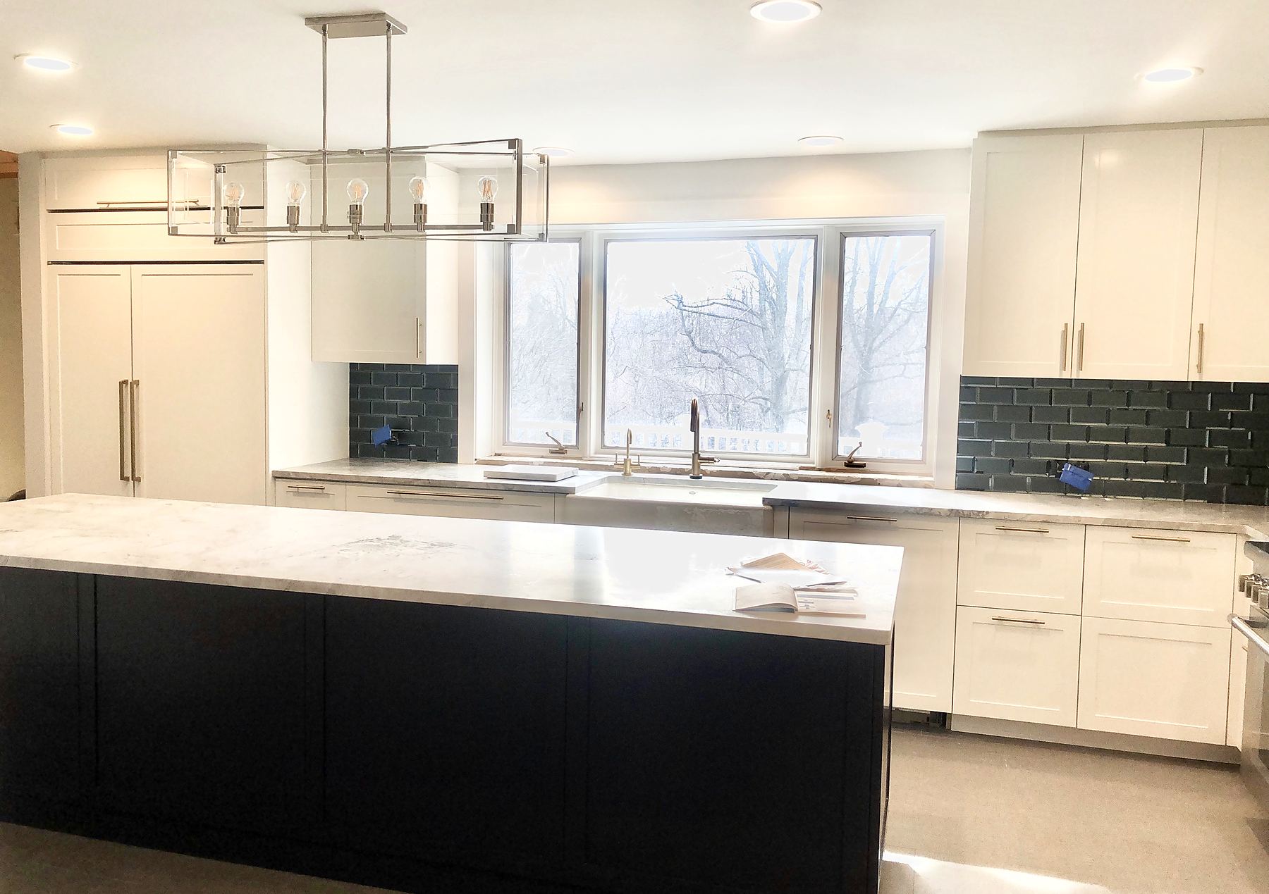 Kitchen with white cabinets, a navy island, and navy tile