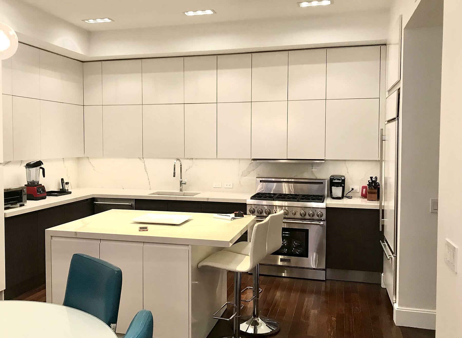 White kitchen with flat-panel cabinets and an island