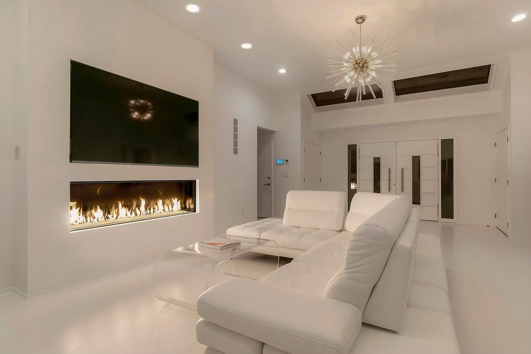 White living room with a linear fireplace under a wall-mounted television