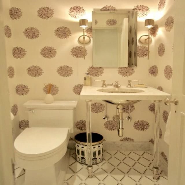 Powder room with floral wallpaper and a console sink