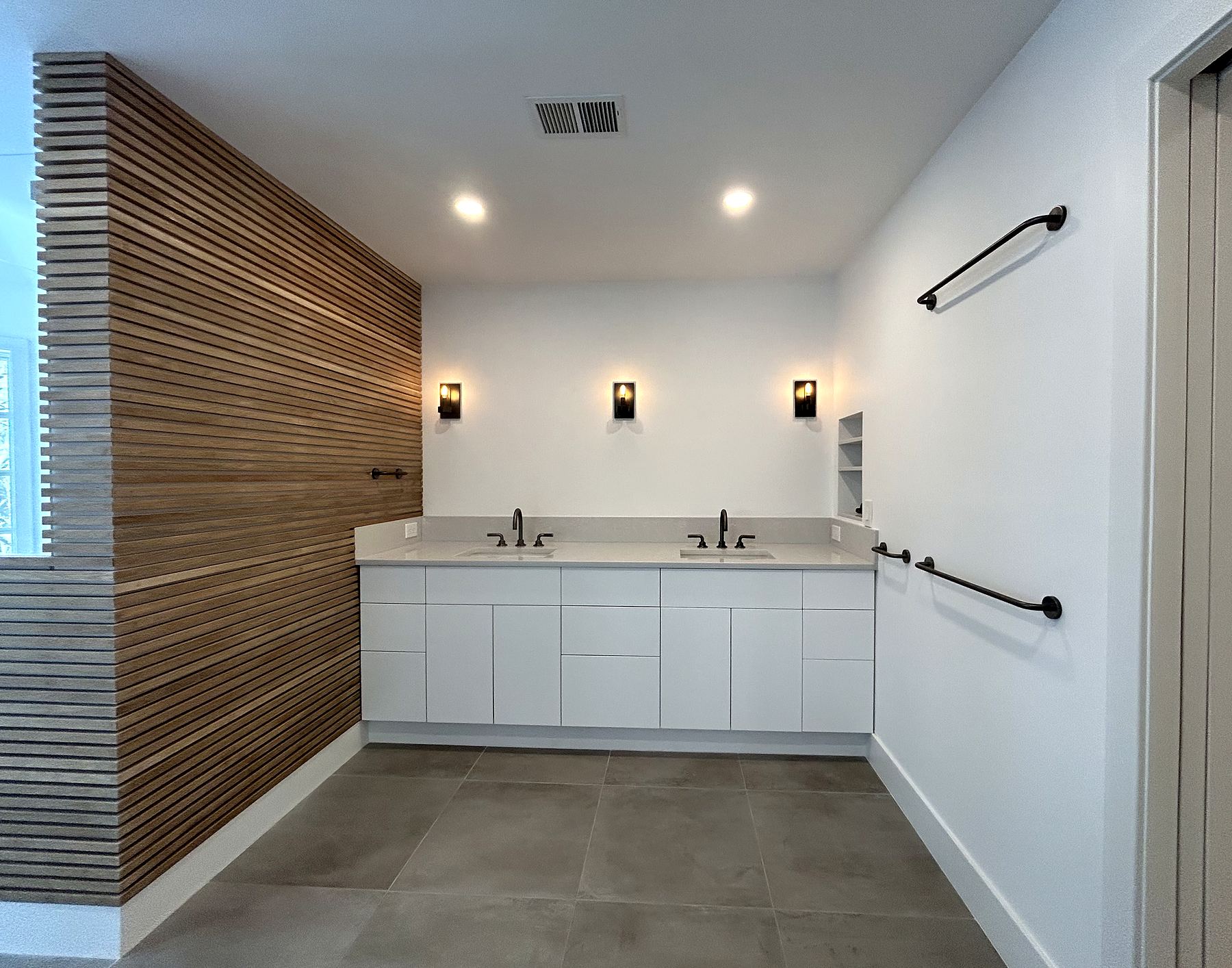 White double vanity beside a wood slat wall